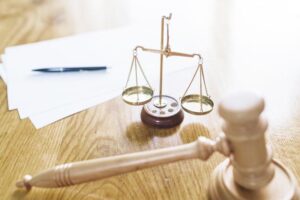 Gavel justice scale pen and blank papers on wooden desk 23 2147876593