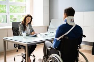 Injured man in wheelchair speaks with attorney about disability