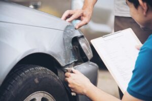 Savannah Accident Reconstruction Lawyers | Free Initial Consultation An accident reconstructionist takes notes on the damage of a vehicle.