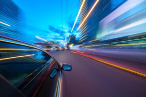 Speeding Accident Lawyer | 24/7 Support | Hablamos Español A car drives so fast, the lights outside the vehicle begin to blur.