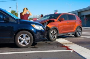 Savannah Red Light Accident Lawyers | John Foy & Associates The aftermath of a car accident at an intersection. A red truck collided with a silver SUV