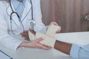 When Should You See a Doctor After a Dog Bite? | 24/7 Support Available A doctor wraps a bandage around her patient’s hand.