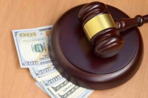 How Long Will It Take to Settle a Claim for a Dog Bite Injury? A gavel rests on top of fanned out hundred dollar bills.