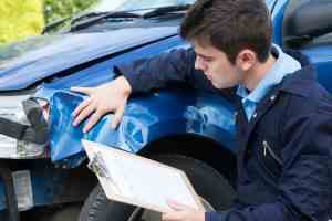An accident reconstruction expert investigates the damages present on a car.