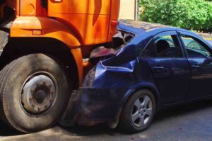 Mableton Garbage Truck Accident Lawyers | Receive a Free Consultation A large orange garbage truck picks up a dumpster to dump into its receptacle.