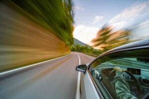 Warner Robins Speeding Accident Lawyers | 24/7 Support Available A car is speeding down the road on a hillside.