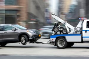 Athens Tow Truck Accident Lawyer | John Foy & Associates A tow truck drags a car while speeding down the street.