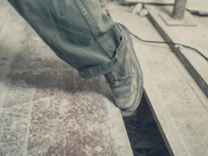 Premises Liability Lawyer in Mableton | John Foy & Associates A person trips over a gap on a poorly maintained wooden floor.
