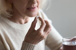 Elmiron Lawsuit | John Foy & Associates A concerned middle-aged woman takes a prescription drug.