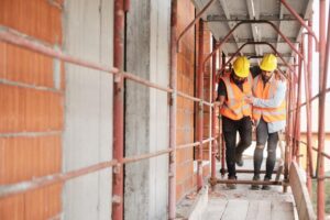Construction Accident Lawyer in Sandy Springs | John Foy & Associates A construction worker helps his injured coworker.