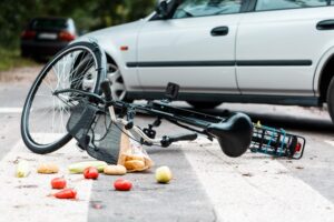 Columbus, GA, Bicycle Accident Lawyer | No Upfront Fees crashed bike with spilled groceries on street near car