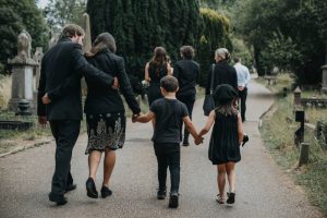 grieving family walking through cemetery