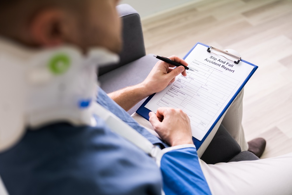 injured man filling out slip and fall accident report 
