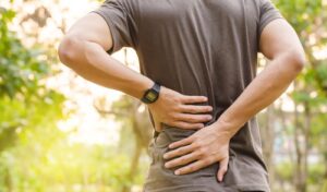 Back Injury Lawyer in Sandy Springs | John Foy & Associates man holds back in pain after accident