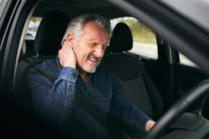 Personal Injury Lawyer in Stonecrest | John Foy & Associates an holds injured neck after car accident