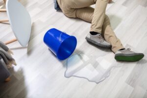 Slip and Fall Lawyer in Ellenwood, GA | John Foy & Associates man lies on floor next to spilled water