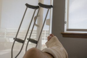 patient with injured leg lies near crutches