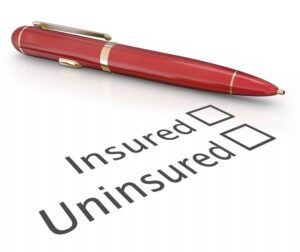 Austell Uninsured Motorist Accident Lawyers | John Foy pen and paper with blank insured and uninsured check boxes