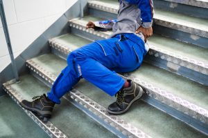 worker holds injured back after falling on stairs