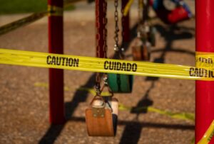 Unsafe Premises Property Negligence Lawyer in Columbus, GA Caution tape around a swing set on a playground.