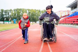 woman in wheelchair and child race on track