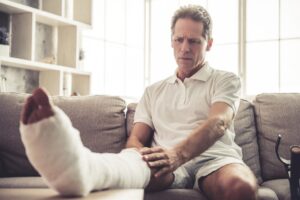 Catastrophic Injury Lawyer in Decatur | 24/7 Support man touching his broken leg in a cast