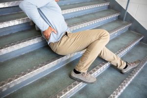 fallen man on staircase experiencing back pain