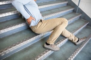 College Park Slip and Fall Lawyers | John Foy & Associates fallen man on staircase experiencing back pain