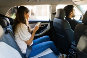 Lawrenceville Uber Accident Lawyers | 24/7 Help woman on her phone in an uber