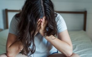 Covington Wrongful Death Lawyers | John Foy & Associates grieving woman sitting on bed