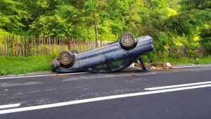 overturned blue car on the road
