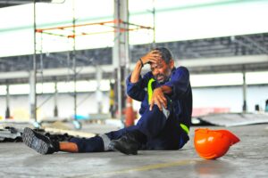 fallen construction worker holds head and knee