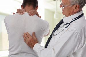 doctor helping patient with back pain