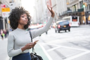 Uber Accident Lawyer in Albany | Free Consultations woman hailing a rideshare ride