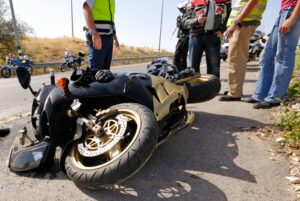 Motorcycle Accident Lawyer in Buford | 24/7 Help men standing around a crashed motorcycle