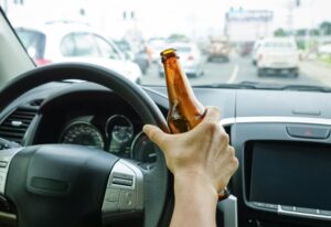 Drunk Driving Accident Lawyer in Dublin | Free Consults person holding a beer bottle while driving
