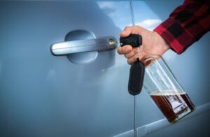 Drunk Driving Accident Lawyer in Lithia Springs man unlocking the car door with beer bottle in hand