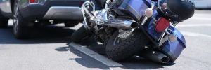 close-up on motorcycle trapped under car