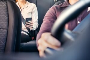 woman-checking-phone-in-a-rideshare-car