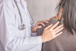 woman with shoulder injury with doctor