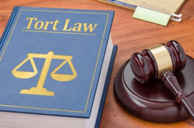Tort law book and gavel scaled