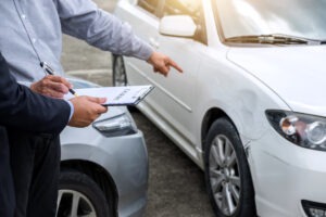 insurance agent examine damaged car