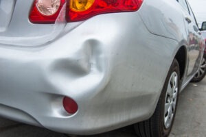 silver car with dented bumper
