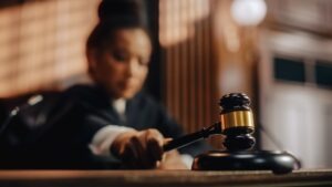 blurred image of a female African American judge striking a gavel.