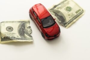 A toy car passing through a ripped $100 bill. An uninsured or underinsured driver can destroy your finances, but UI/UIM coverage works to protect you.