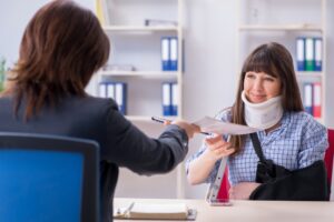 Woman in sling and neck brace meets with Georgia workers' compensation attorney after Kroger accident