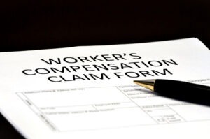A paper on a clipboard reads 'workers' compensation claim form.' Can I get a settlement from workers' compensation if I go back to work?