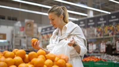 The Average Settlement for a Slip and Fall at Walmart A woman looks at oranges at Walmart, moments before a slip and fall accident. She might get more than the average settlement for a slip and fall at Walmart.