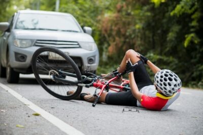 How Much Do Lawyers Charge for Bike Accident Claims? A cyclist on the ground holding his knee. Learn about how much lawyers charge for bicycle accident claims.