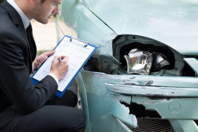 How to get a Crash Report in McCormick, SC | John Foy A man writing down a crash report in McCormick, SC, after an accident.